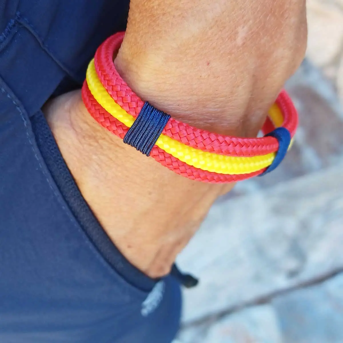 Pulsera España náutica combinada con un polo azul marino