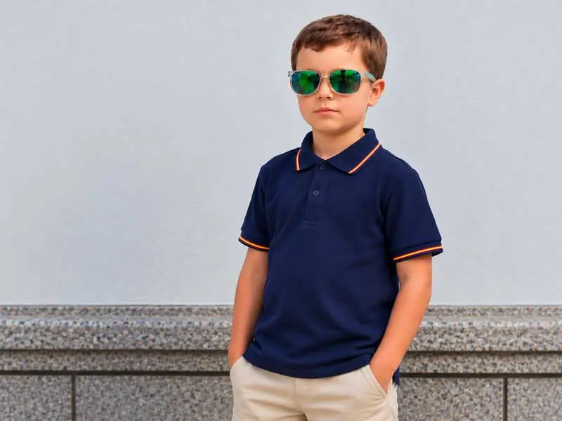 Niño con polo azul marino con detalles de la bandera de España